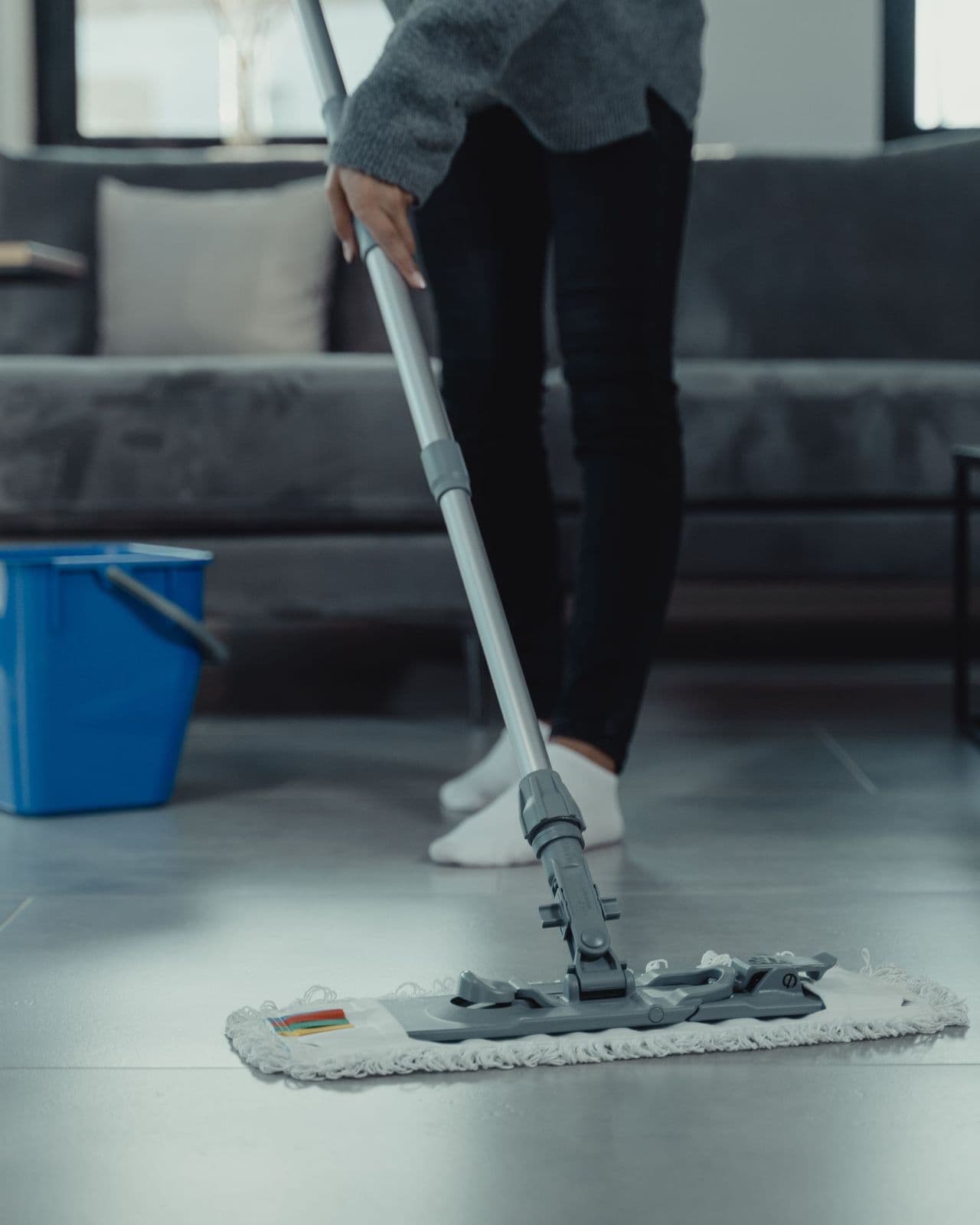 Close-up of a mop cleaning a tiled floor in a bright commercial interior